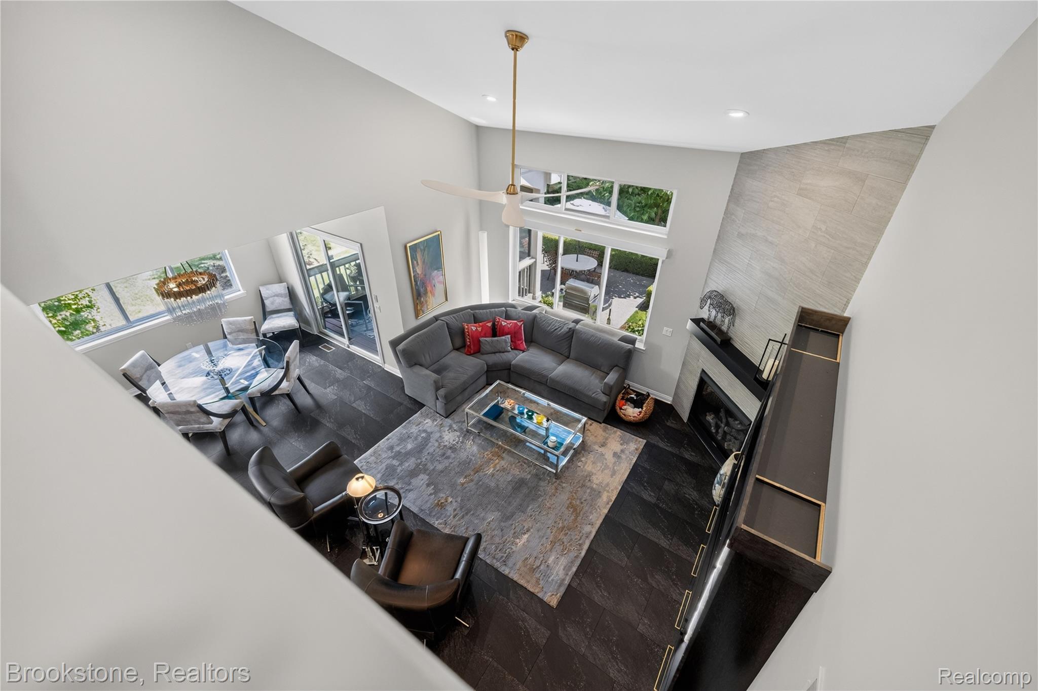 2167 Sanctuary Court Rochester, MI 48309 - Photo 20 of 68 Open-concept living area with vaulted ceilings, dark wood-finish flooring, and a contemporary fireplace featuring a stone-look accent wall