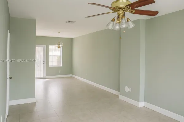 en empty room with windows and fan