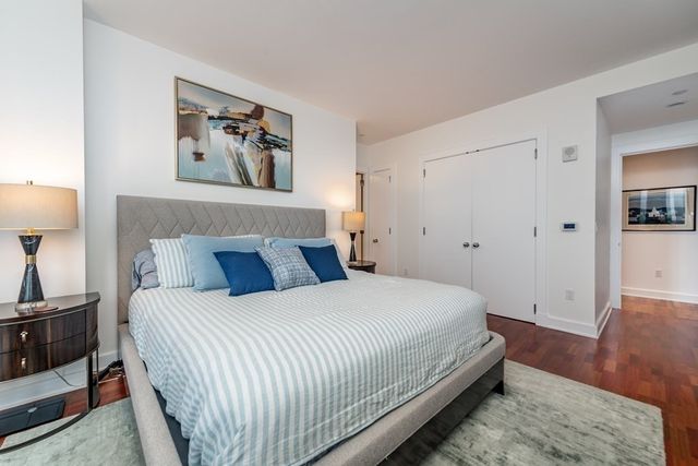 a bedroom with a bed and a painting on the wall