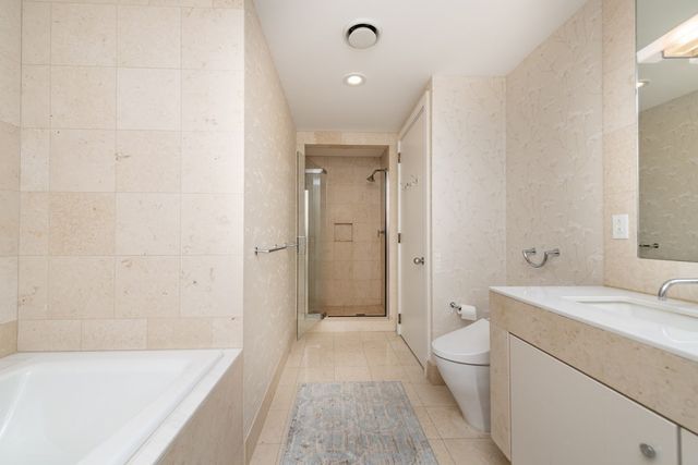 a bathroom with a sink a toilet a tub and shower