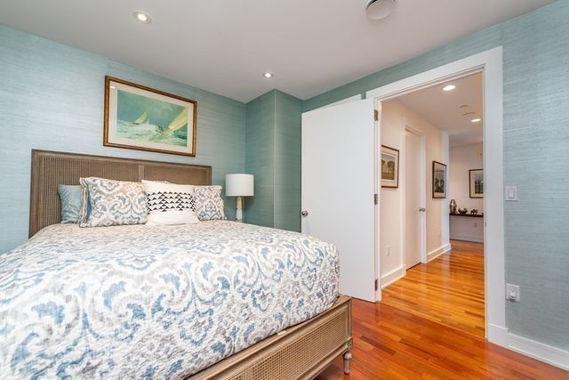 a bedroom with a bed and painting on the wall