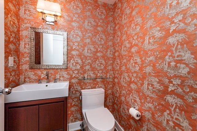 a bathroom with a toilet sink and mirror