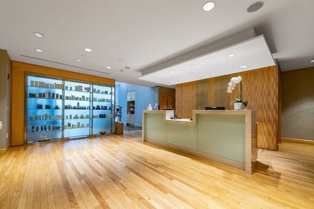 a view of a big room with wooden floor and windows