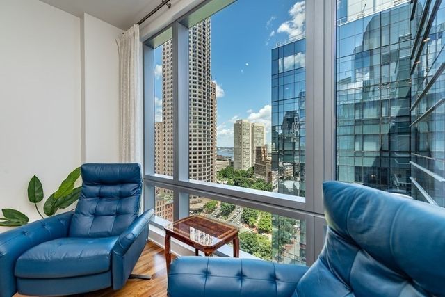 a living room with furniture and a floor to ceiling window