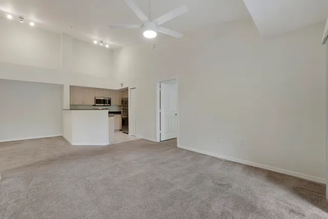 an empty room with kitchen and stainless steel appliances