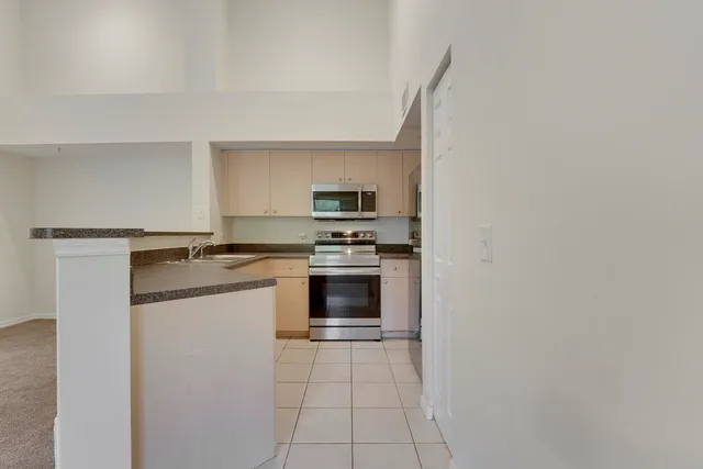 a kitchen with granite countertop a refrigerator and a stove top oven