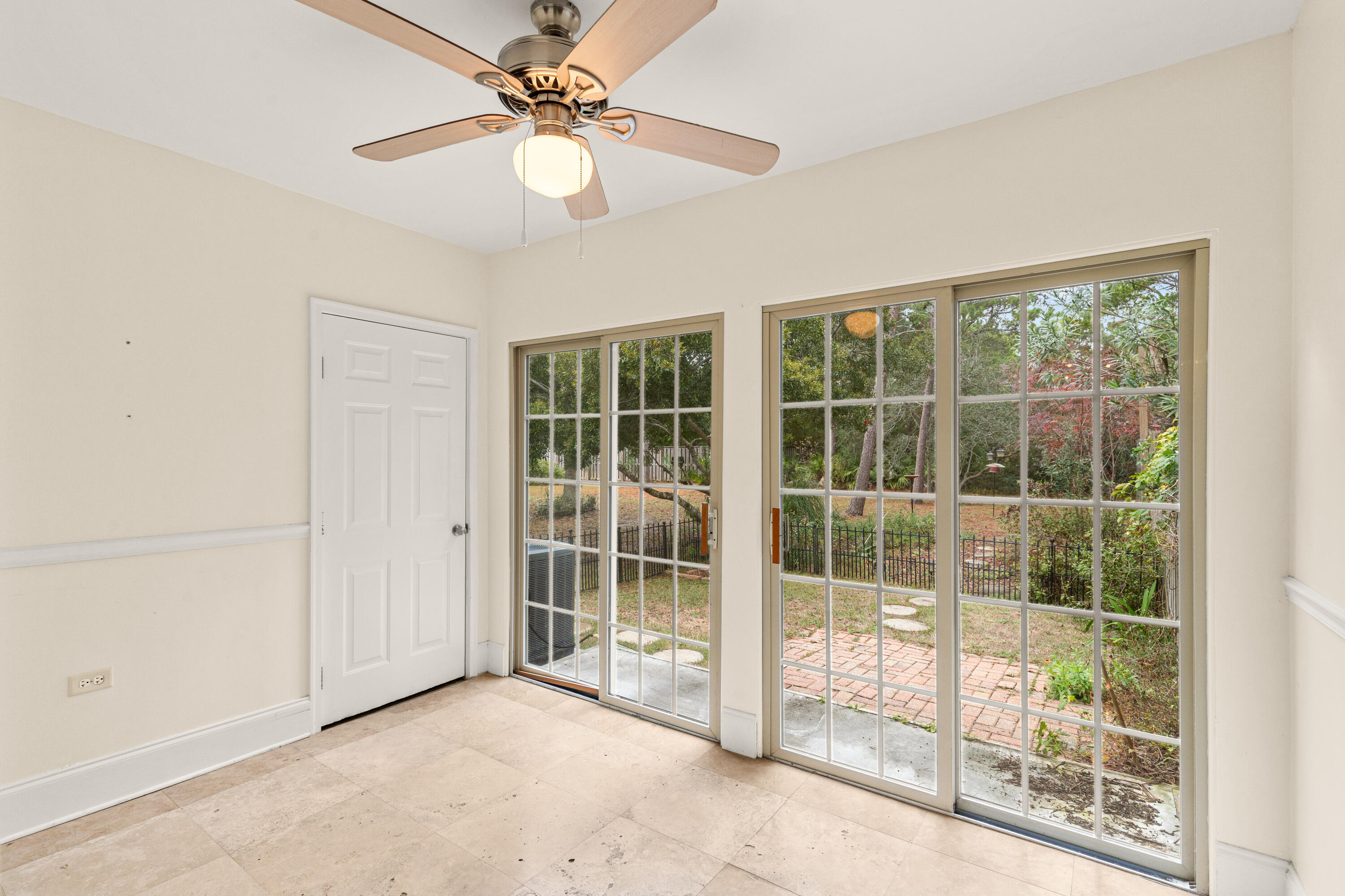 162 Vía Largo, Unit 22B Santa Rosa Beach, FL 32459 - Photo 18 of 26 an empty room with floor to ceiling windows and a ceiling fan
