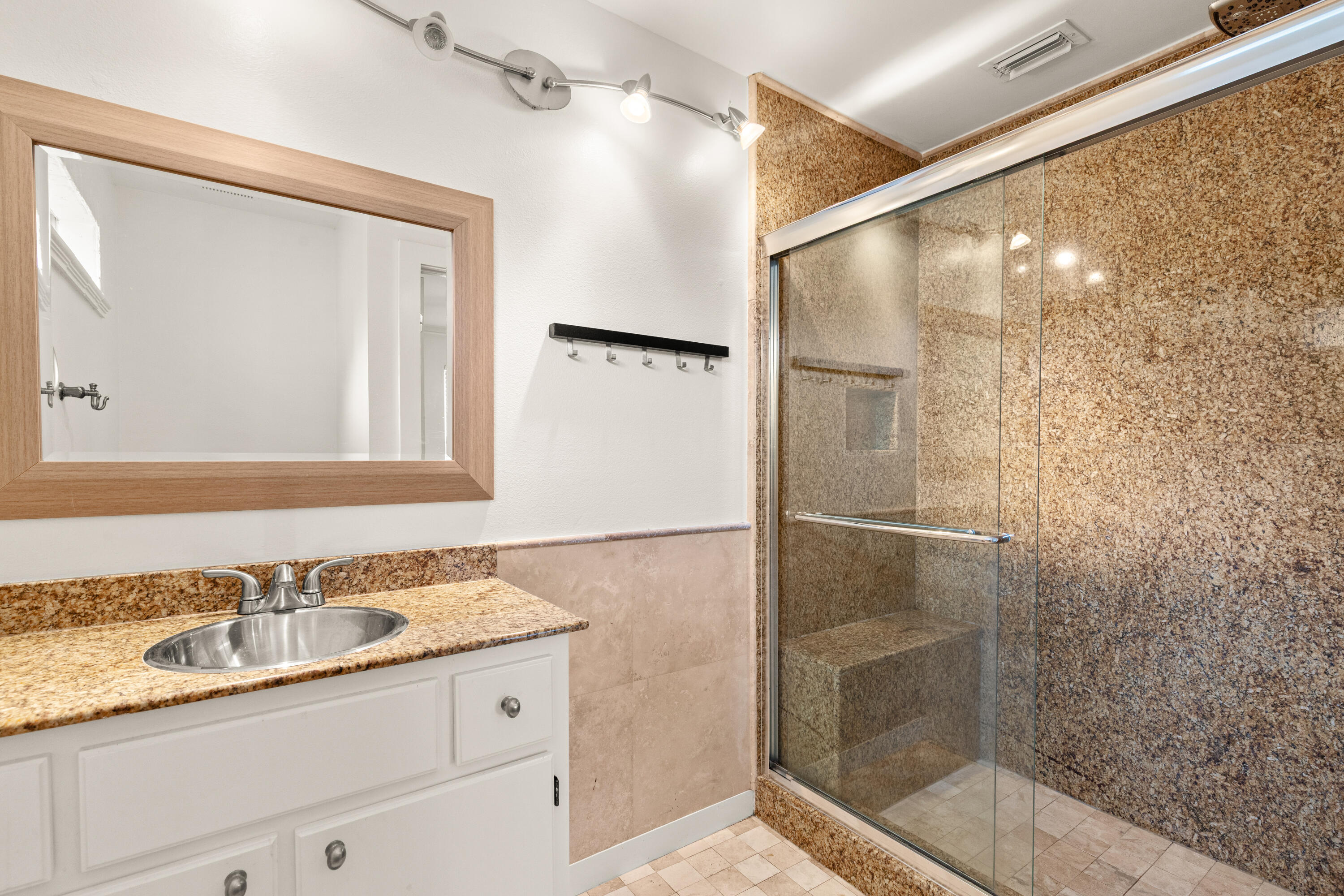 162 Vía Largo, Unit 22B Santa Rosa Beach, FL 32459 - Photo 23 of 26 a bathroom with a granite countertop sink mirror and shower