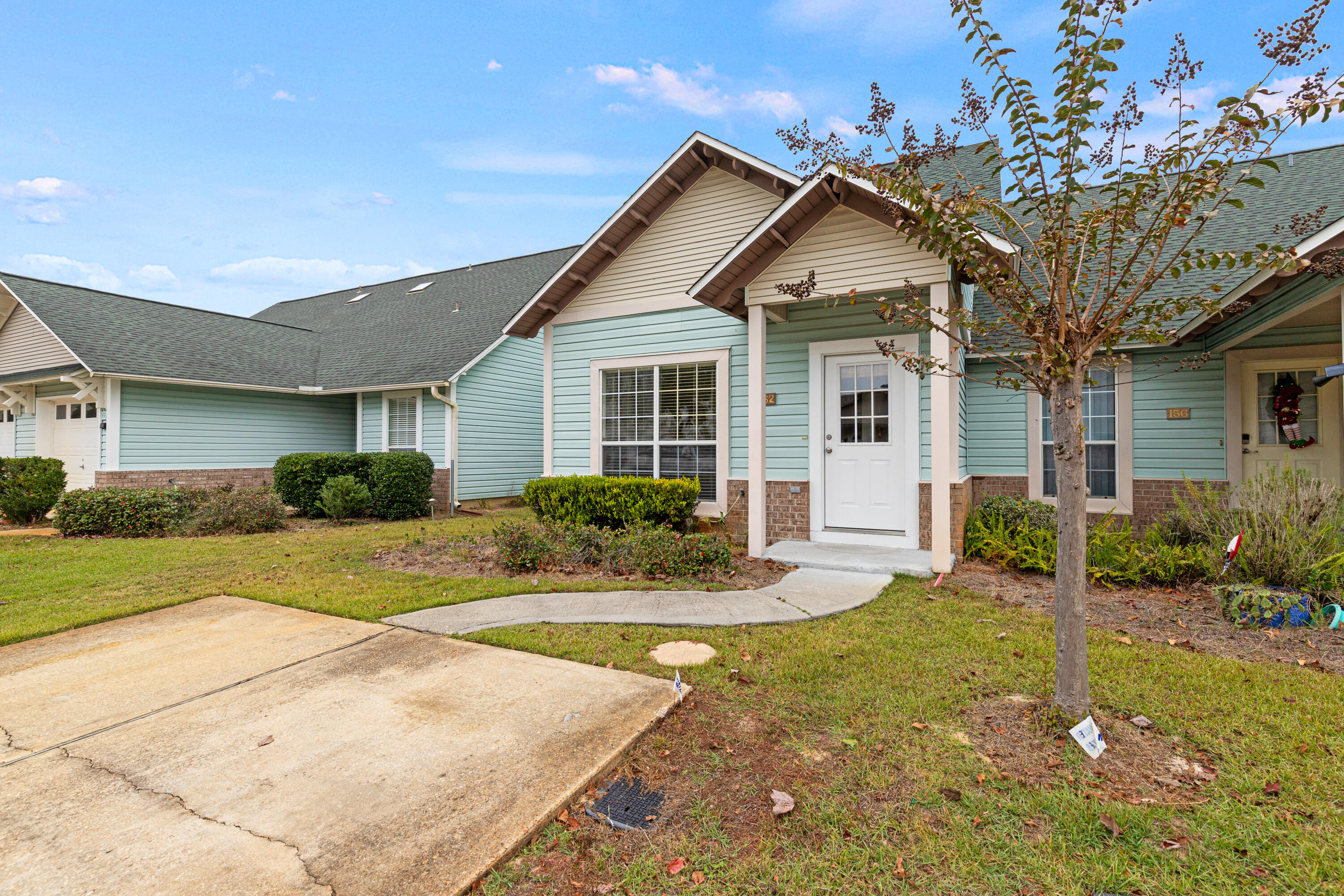162 Vía Largo, Unit 22B Santa Rosa Beach, FL 32459 - Photo 3 of 26 a front view of a house with a yard and potted plants