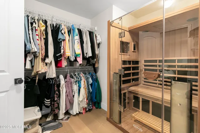 a view of walk in closet with clothes and shoes