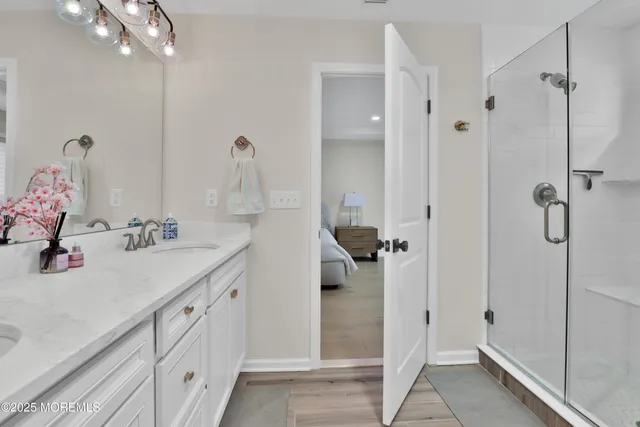 a bathroom with a double vanity sink a shower and a mirror