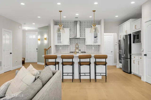 a living room with stainless steel appliances kitchen island granite countertop furniture and a couch