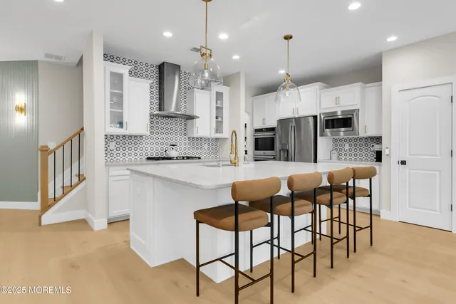 a kitchen with kitchen island granite countertop a view of living room and stainless steel appliances