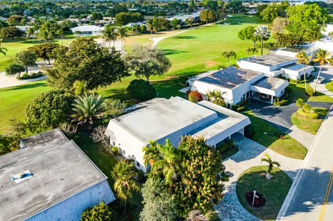 an aerial view of residential houses with outdoor space and swimming pool