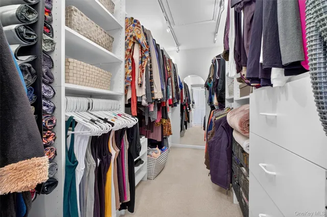 a view of walk in closet with clothes and shoes