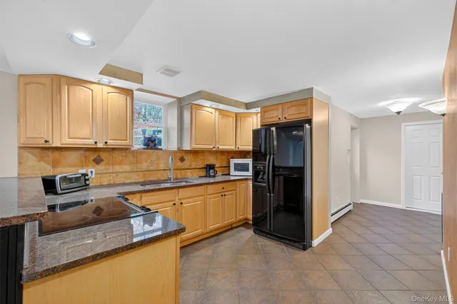 a kitchen with stainless steel appliances granite countertop a refrigerator and a sink