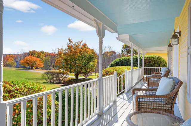 a balcony with wooden floor table and chairs