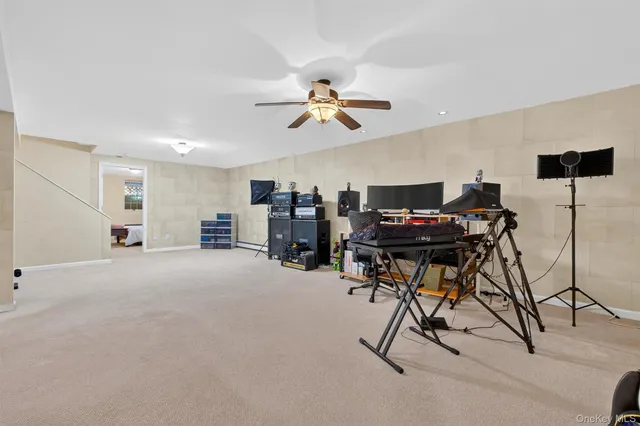 a view of a workspace with furniture and a ceiling fan