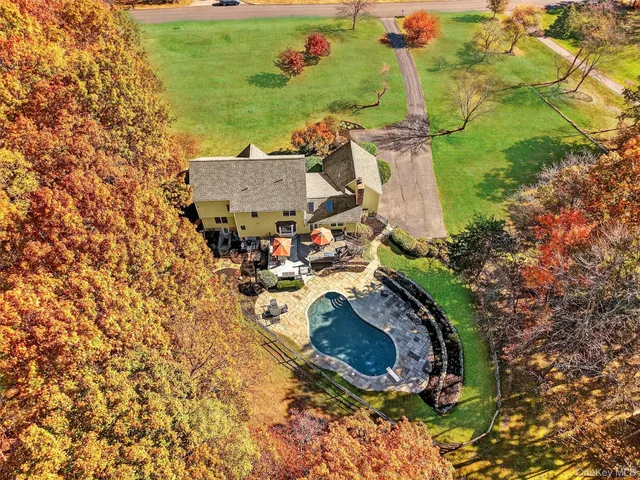 an aerial view of a house with a yard basket ball court and outdoor seating
