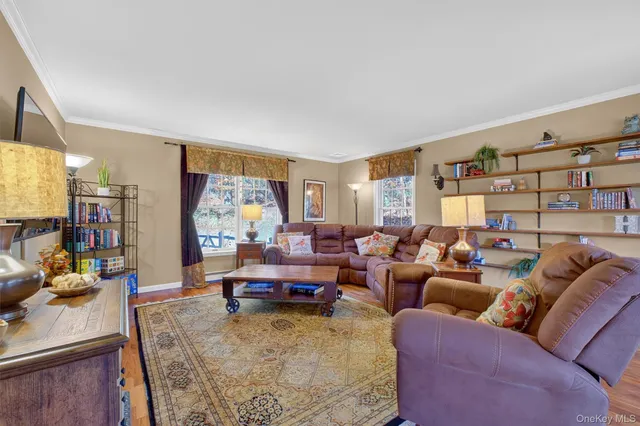 a living room with furniture kitchen view and a large window