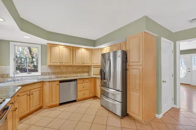 a kitchen with granite countertop a refrigerator and a sink