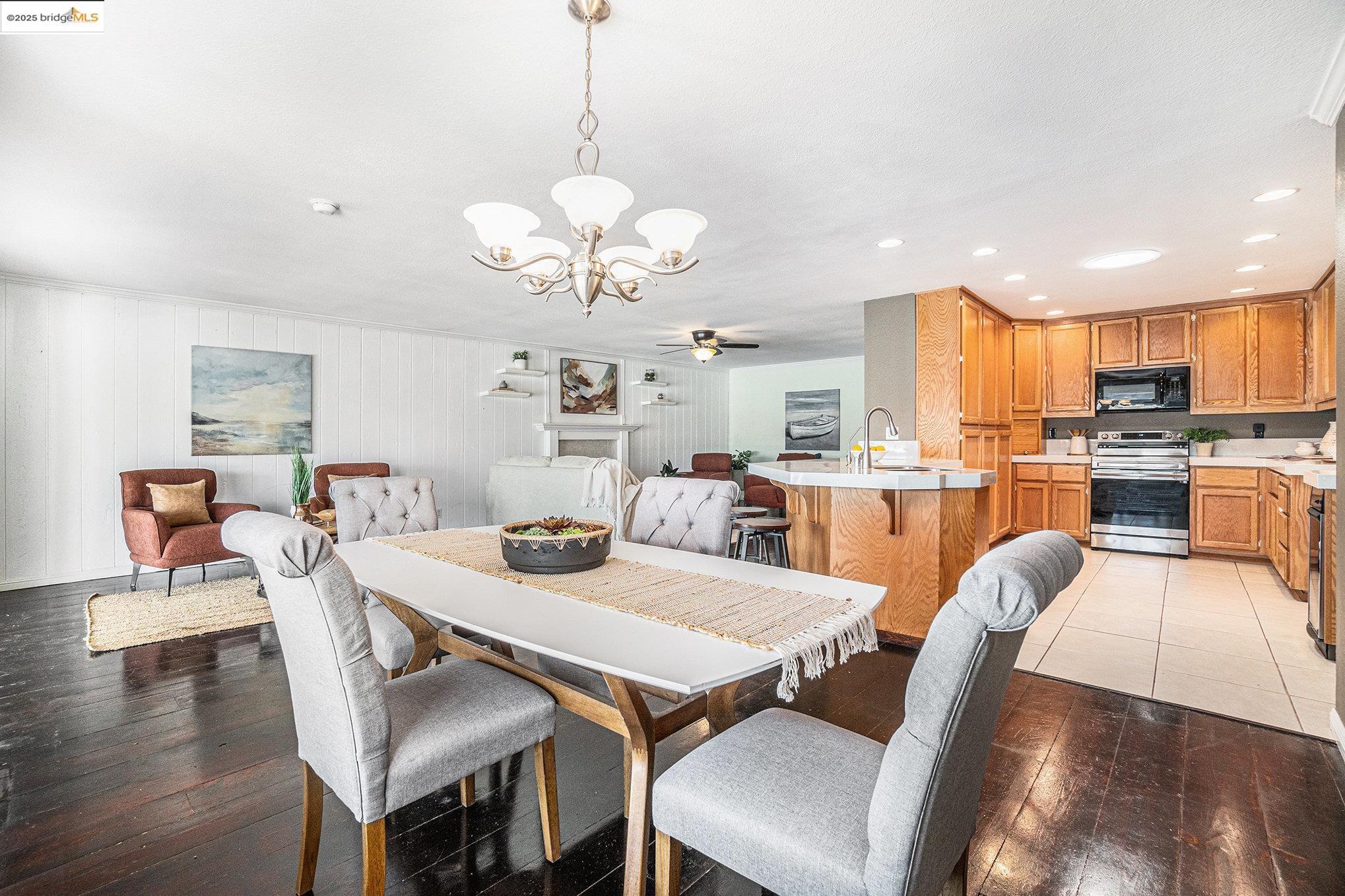 870 Willow Lake Road Discovery Bay, CA 94505 - Photo 11 of 39 a view of a dining room with furniture a chandelier and wooden floor