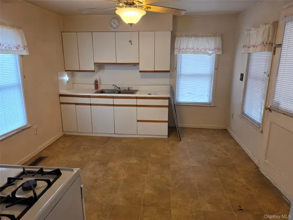 a kitchen with granite countertop a sink stove and refrigerator