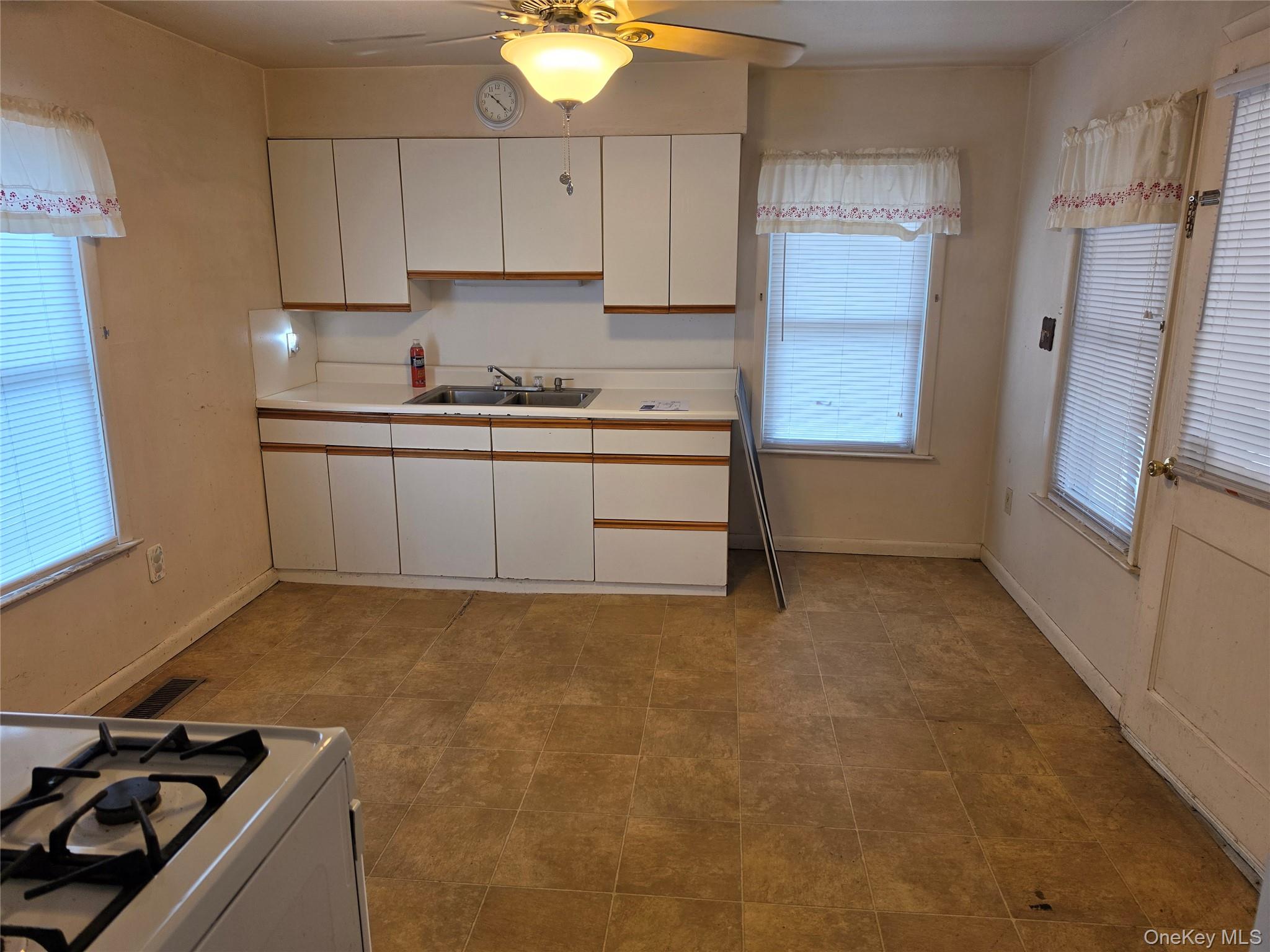 28-34 Townsend Avenue Flanders, NY 11901 - Photo 4 of 11 a kitchen with granite countertop a sink stove and refrigerator