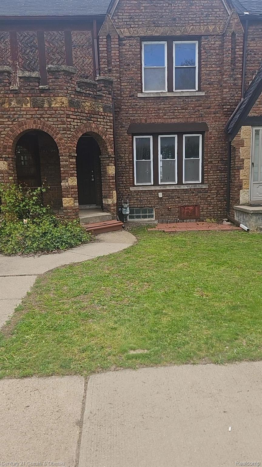 View of front facade featuring a front lawn and brick siding