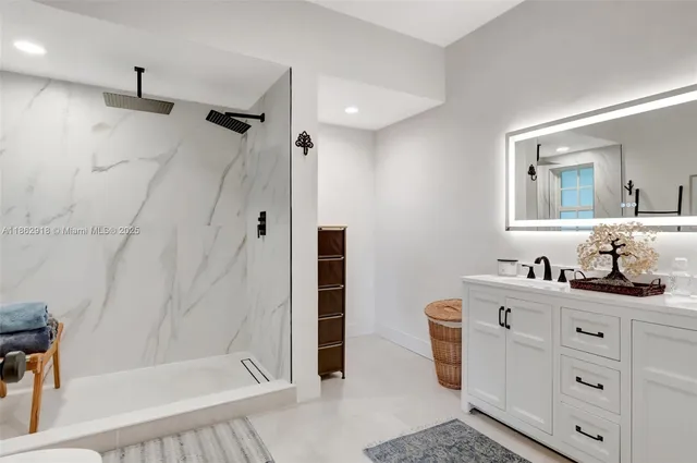 a bathroom with a sink a toilet a mirror and shower