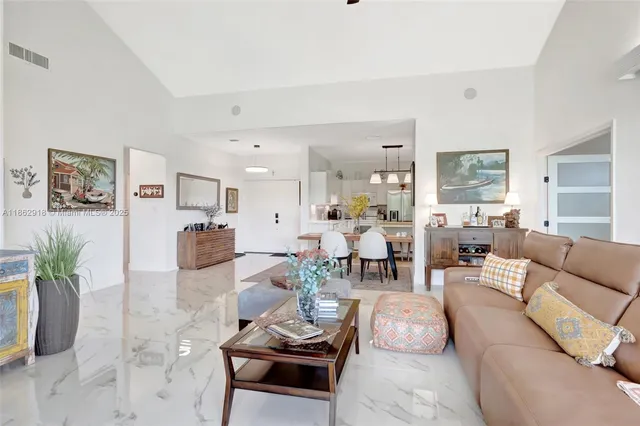 a living room with furniture kitchen and a table