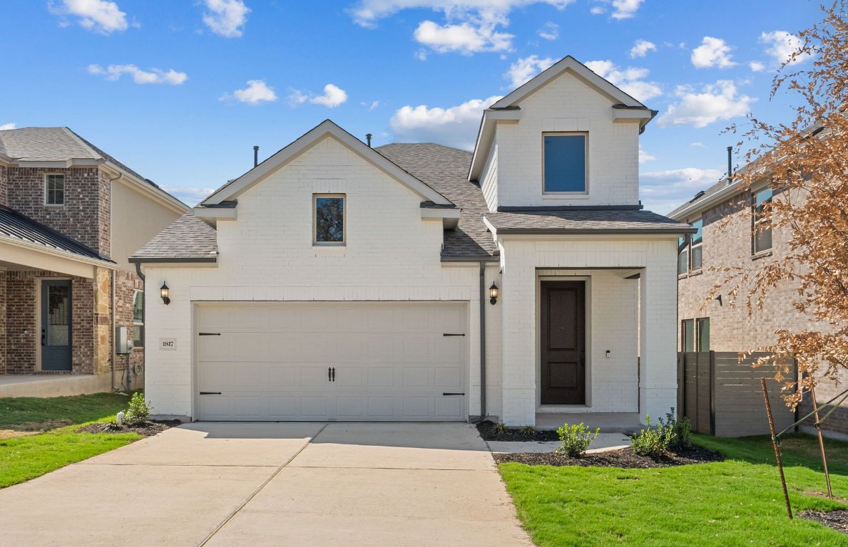 1817 Spg Mountain Cove Georgetown, TX 78628 - Photo 1 of 27 a front view of a house with a yard and garage