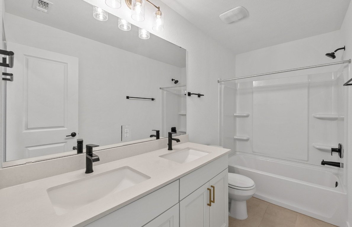 1817 Spg Mountain Cove Georgetown, TX 78628 - Photo 21 of 27 a bathroom with a sink a toilet and a mirror