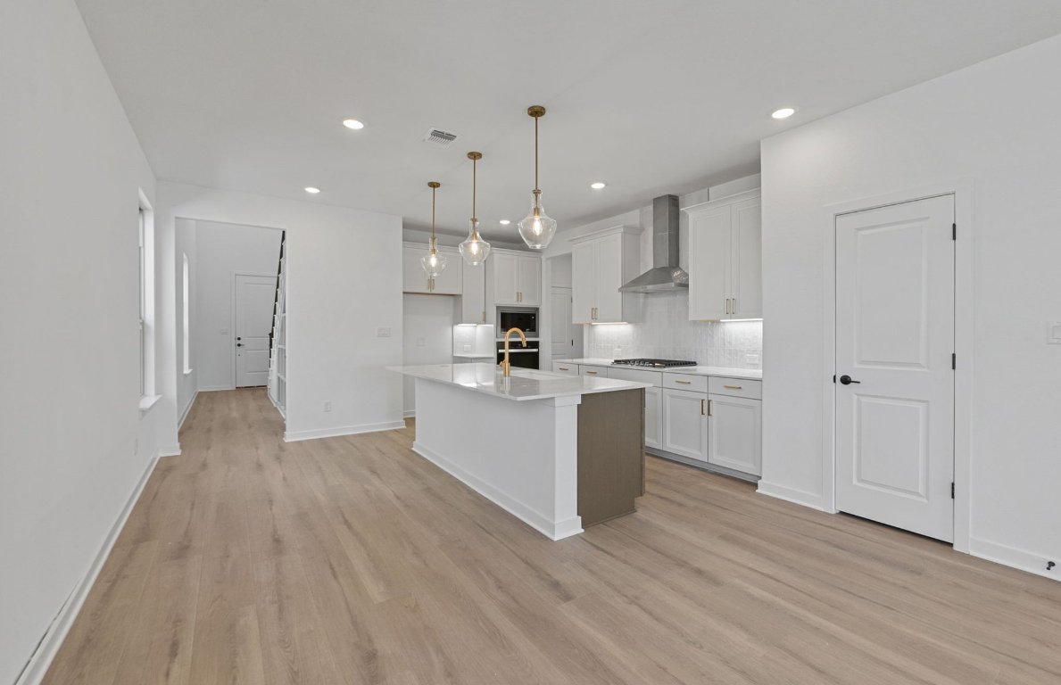 1817 Spg Mountain Cove Georgetown, TX 78628 - Photo 5 of 27 a large kitchen with lot of cabinets and wooden floor