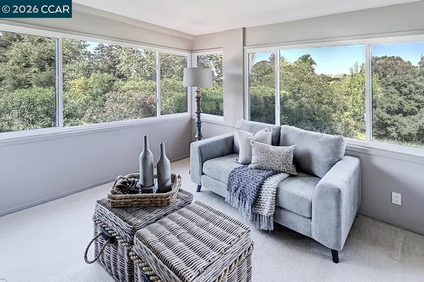 a living room with furniture and a floor to ceiling window