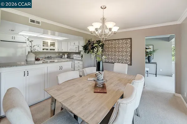 a view of a dining room with furniture a chandelier and wooden floor