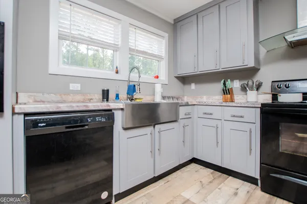 a kitchen with stainless steel appliances granite countertop a sink stove and cabinets