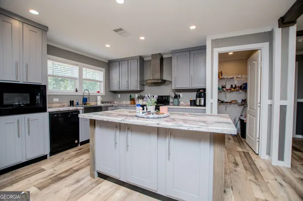 a kitchen with stainless steel appliances granite countertop a sink a stove a refrigerator and cabinets