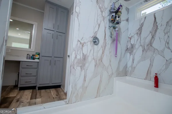 a bathroom with a granite countertop sink mirror and bathtub