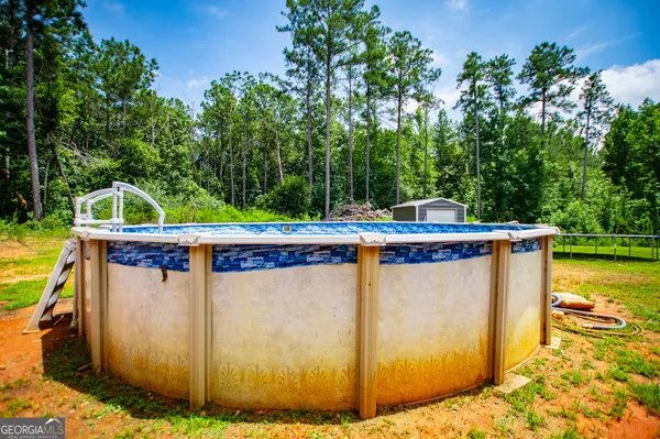 a view of backyard with swimming pool and green space