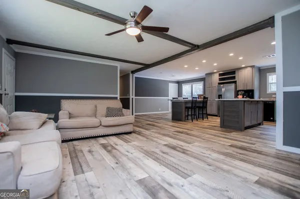 a living room with furniture and kitchen view