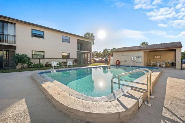 a view of a house with swimming pool and sitting area