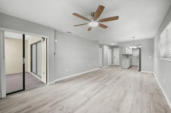 a view of a livingroom with wooden floor and a ceiling fan