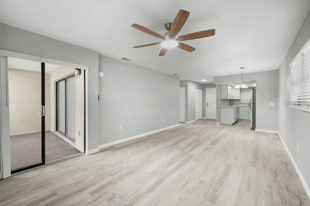 a view of a livingroom with wooden floor and a ceiling fan