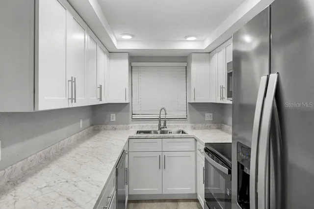 a kitchen with stainless steel appliances granite countertop a sink stove and refrigerator