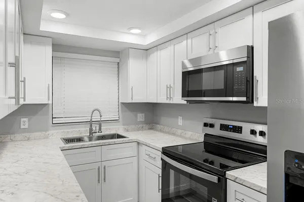 a kitchen with stainless steel appliances a sink stove and microwave