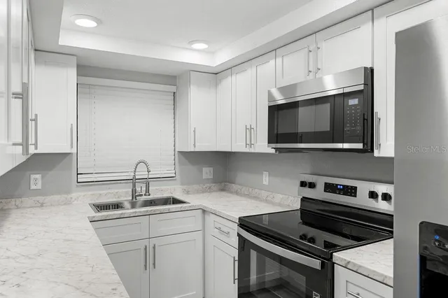 a kitchen with stainless steel appliances a sink stove and microwave