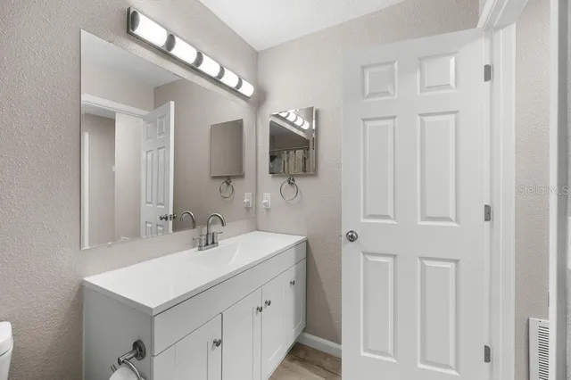 a bathroom with a sink vanity and a mirror