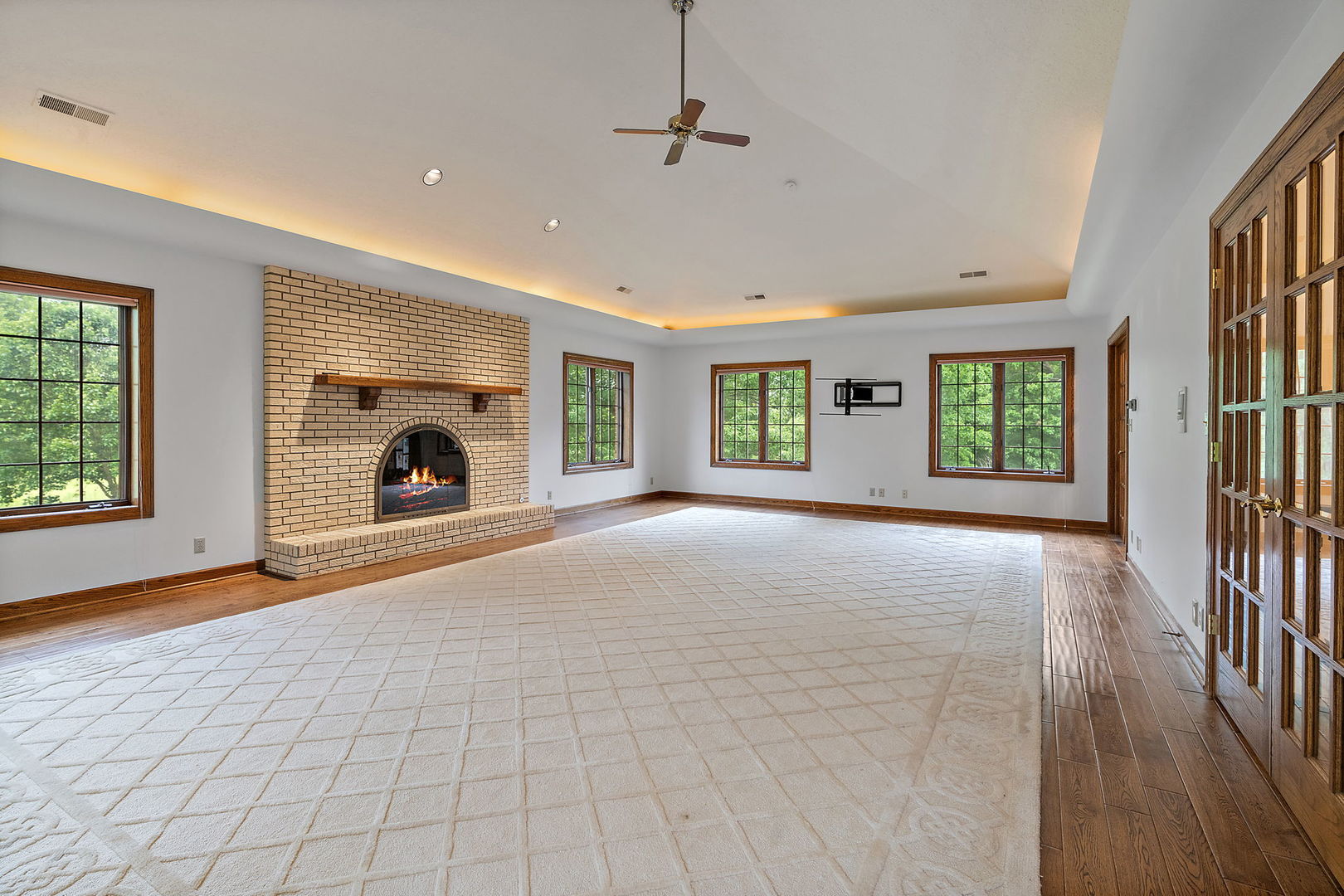 345 Bethany Road DeKalb, IL 60115 - Photo 23 of 71 a view of a livingroom with a fireplace a ceiling fan and windows