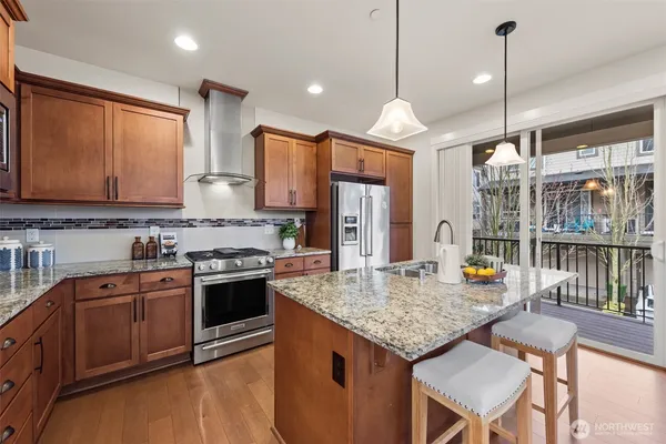 a kitchen with stainless steel appliances granite countertop stove top oven and cabinets